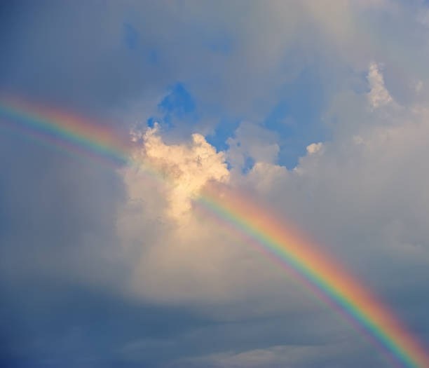 istock rainbow against the background of clouds. 930875650