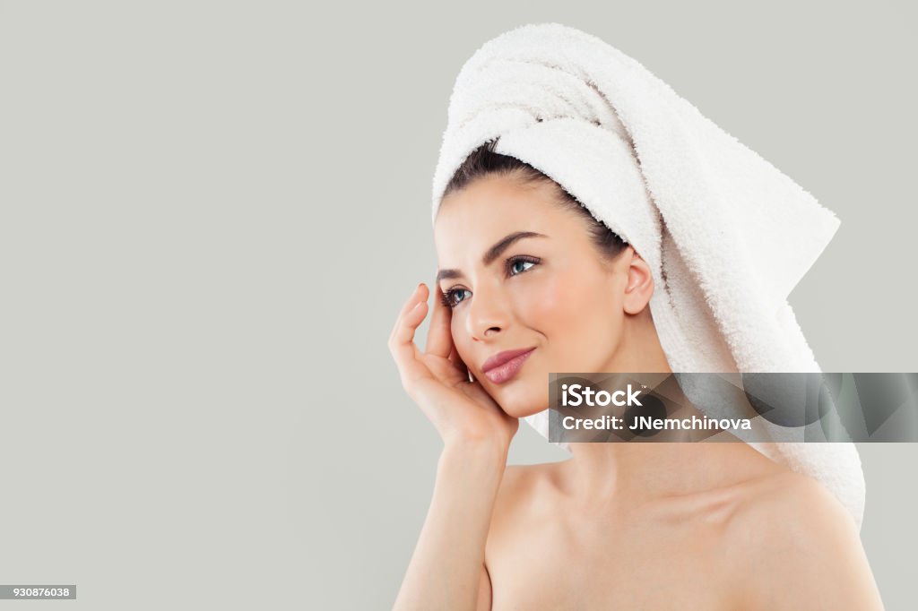 Spa visage féminin. Femme dans une serviette blanche sur la tête sur fond - Photo de Masque de beauté libre de droits