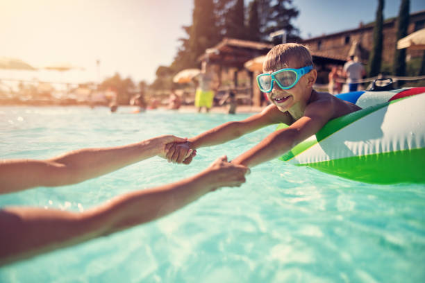 istock Little boy playing with mother in swimming pool 930884010