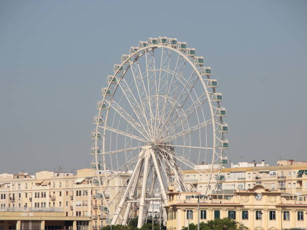 istock Large White Ferris Wheel with City Background 930884214