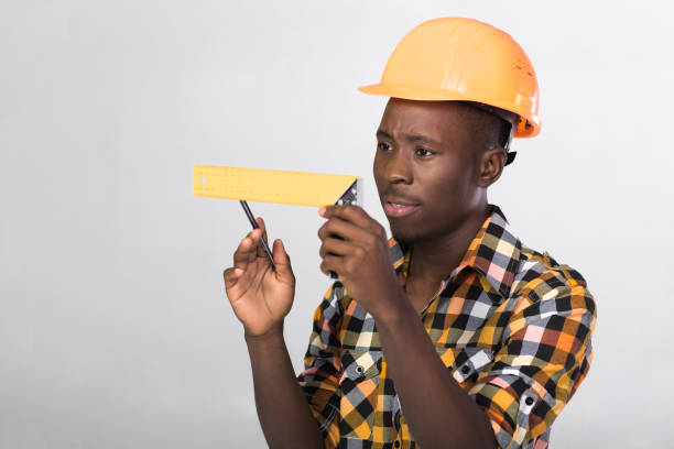istock African-American builder uses measuring tape 930885194