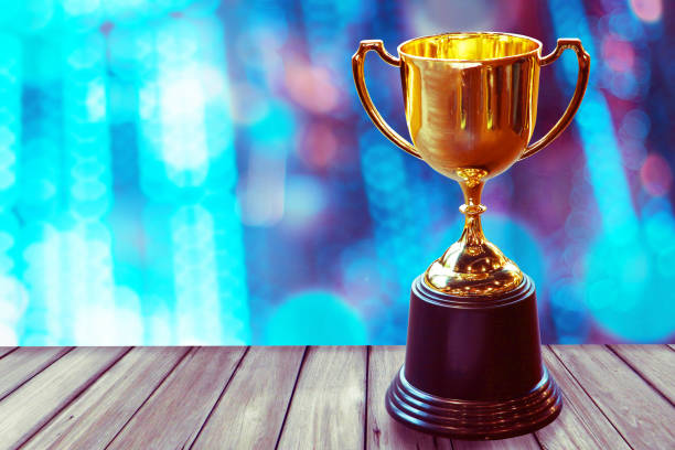 istock Chamption trophy on wood table with abstract bokeh light background, win concept. 930889558