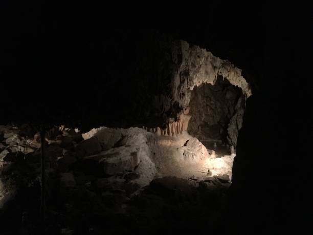 istock Underground exploring a cave with unusual formations. Long stalagmites and stalactites inside a cave in Czech Republic. Deep inside a dark cave. 930889868