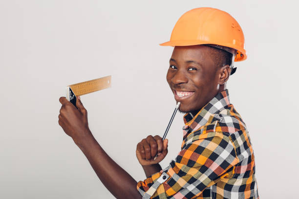 istock African-American builder uses measuring tape 930890486