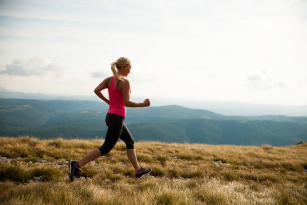 istock runner - woman runs cros country on a path in early autumn 930893692