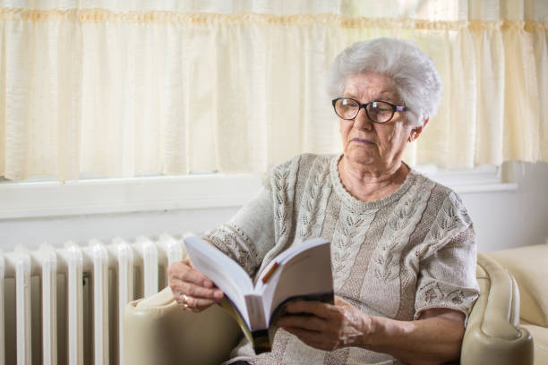 istock Elder woman reading a book at home. 930893864