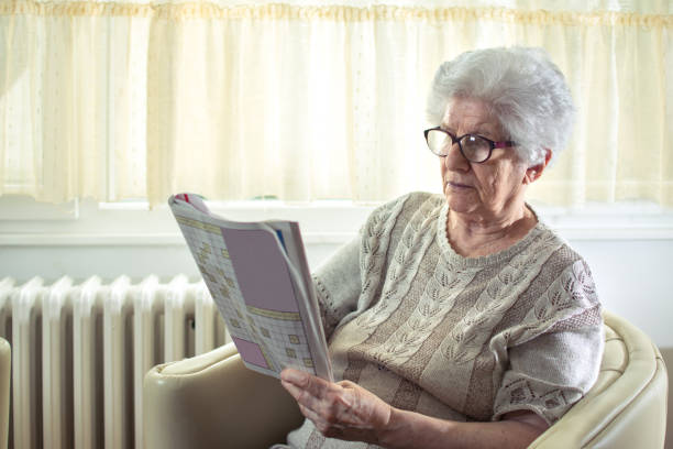 istock Senior woman solving a crossword puzzle at home. 930896050