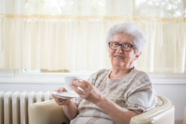 istock Smiling senior woman drinking coffee at home. 930896686