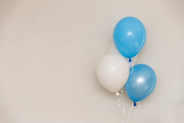 istock Blue and white balloons on light grey wall background. Gender reveal party. 930899188