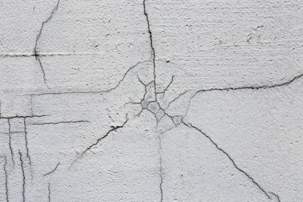 istock Texture of white dirty cracked wall. Small straight cracks. Direct fracture on painted surface. Cells fissure 930902310