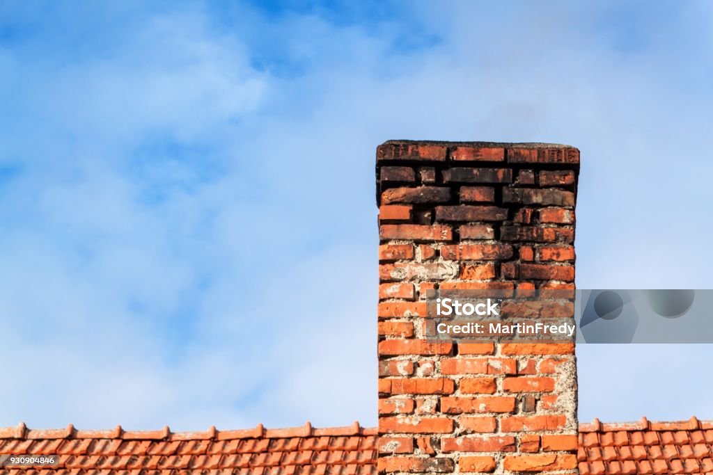 Old brick chimney. Chimney with sky in the background. Eco-friendly heating of a family house. Old brick chimney. Chimney with sky in the background. Eco-friendly heating of a family house Chimney Stock Photo