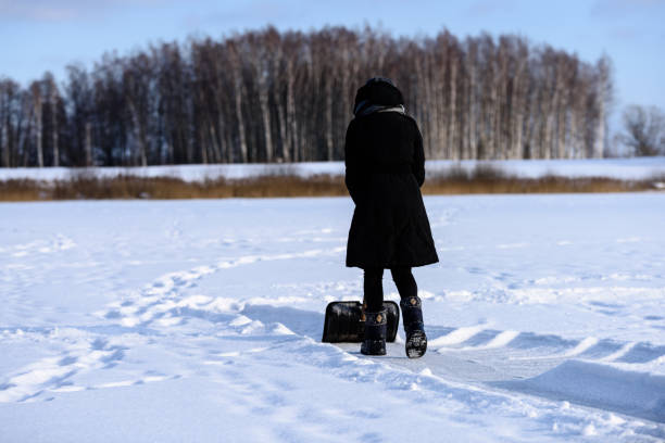 istock young woman in black coat cleaning ice from snow 930909950