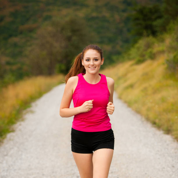 istock runner - woman runns  on a forest road - outdoor  workout 930929250