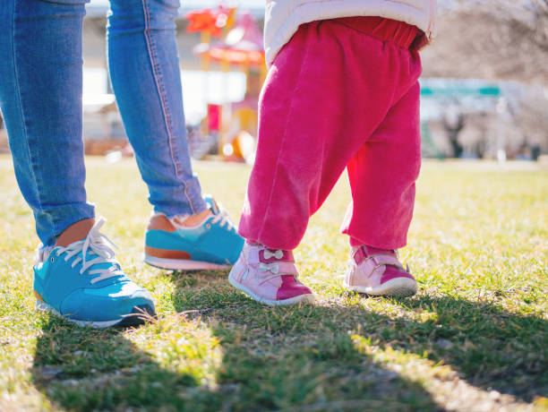 istock First steps for baby girl with mother 930930650