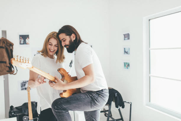 istock Man learning woman how to play guitar 930933404
