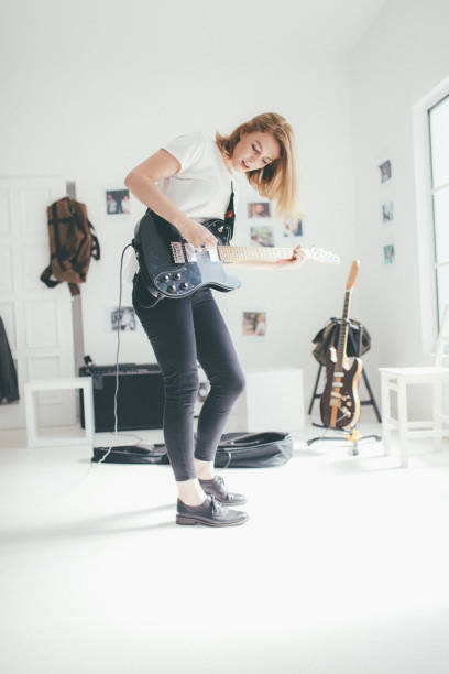 istock Young woman playing guitar 930936506