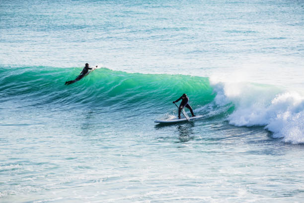 istock Surfer ride on stand up paddle board on ocean blue wave. 930936640