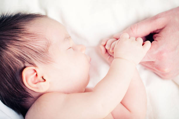 istock Baby and Dad, Newborn and his Father's Hand 930936848