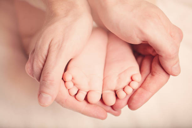 istock Newborn Foot in his Father's Hand 930936854