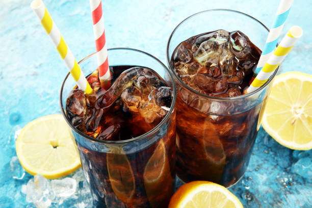 istock Softdrink with ice cubes, lemon and straw in glass. 930944372