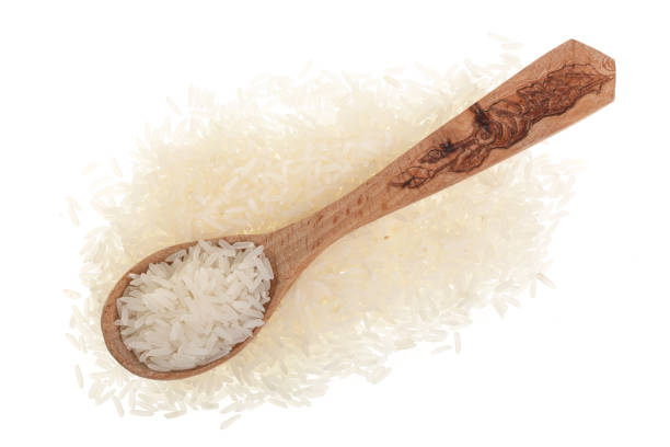 istock rice grains in wooden spoon isolated on white background. Top view. Flat lay 930947578