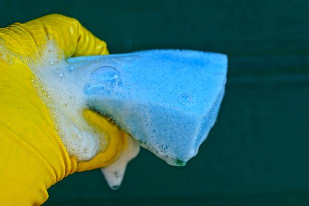 istock blue sponge in foam in hand on a green background 930952500