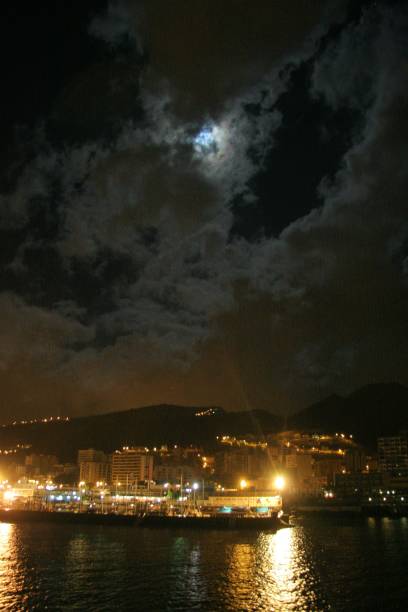 istock Illuminated City By River Against Sky At Night 930955416