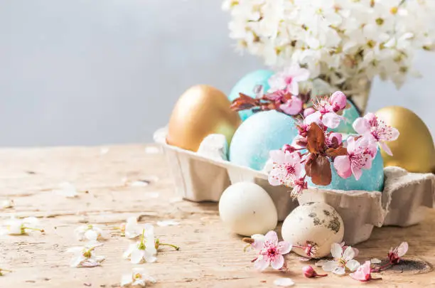 Photo of Easter holiday background with easter colored eggs and spring flowers.