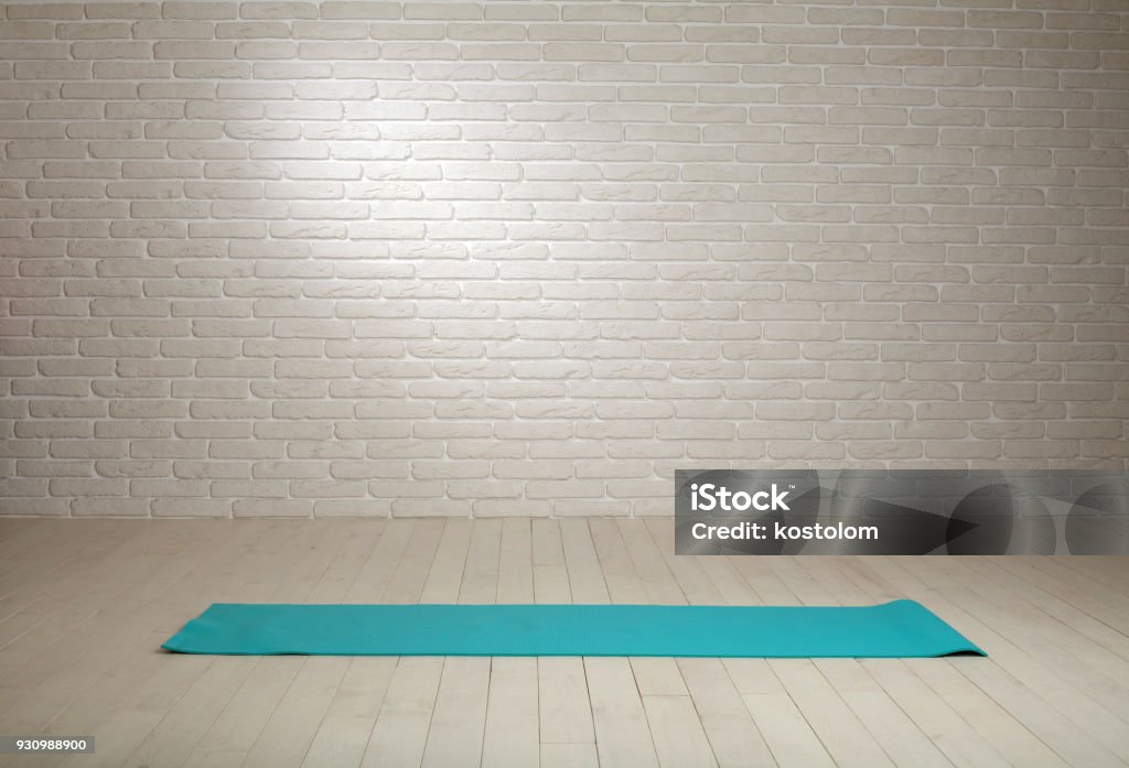 Empty room background wooden floor white brick wall fit mat Empty room background wooden floor white brick wall with fitness mat Backgrounds Stock Photo