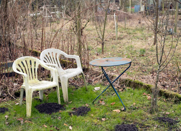 istock derelict garden with old plastic weathered chairs in winter 930989300