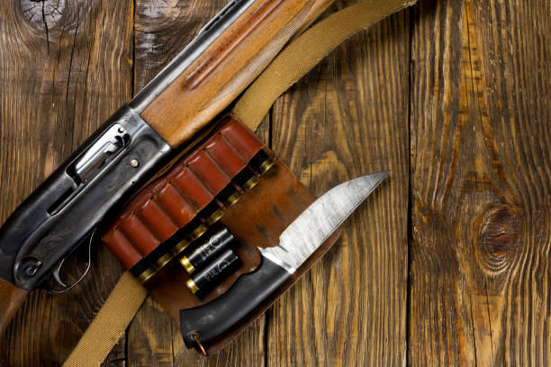 istock Hunting rifle and ammunition lie on wooden background. Copy space 930989420