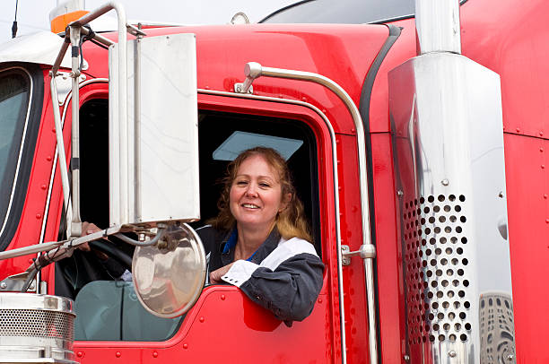 chauffeur de camion femme regardant par la fenêtre - semi truck truck red truck driver photos et images de collection