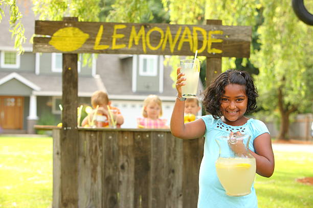 Two hispanic girls putting the last details on her soon to be open lemonade stand