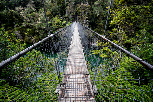 Rope Swing Bridge over blue river in Abel Tasman, New Zealand