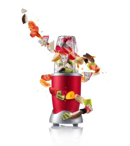 Smoothie maker mixer with pieces of fruit ingredients, isolated on white background. Healthy drink and lifestyle