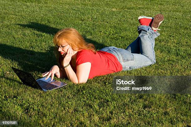 Red Headed Woman Using Laptop Lying On The Grass Stock Photo - Download Image Now - 40-44 Years, 45-49 Years, Adult