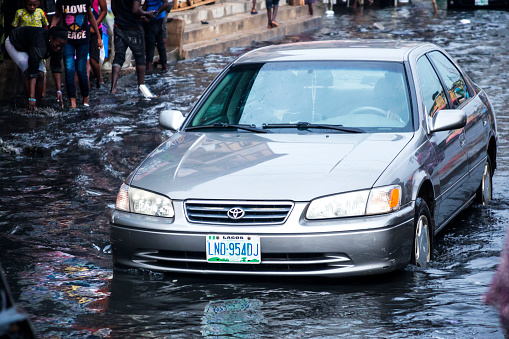 Lagos, Nigeria - February 26, 2016: Rainy season in African city - everyday traffic in flooded market streets.