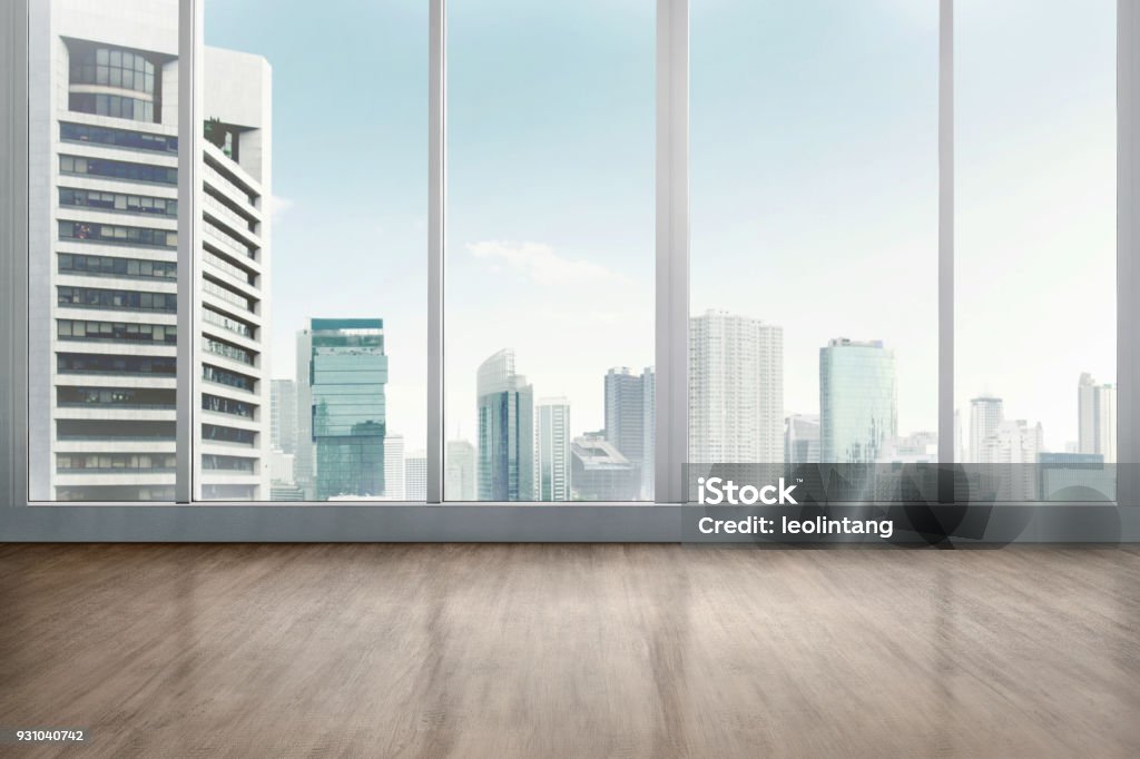 Empty office room with wooden floor Empty office room with wooden floor with cityscape background Window Stock Photo