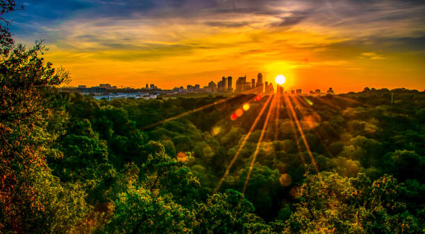 Sunset Sunset over Austin , Texas , USA Skyline Cityscape surrounded by greenbelt nature escape Texas Hill Country City in the distance with sun rays and sunbeams at Sunset southwest usa photos stock pictures, royalty-free photos & images