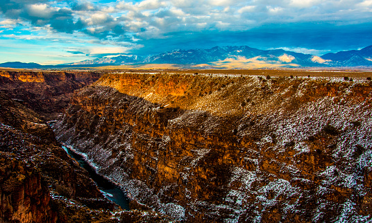 Amazing Sunset above the Rio Grande Gorge near Northern New Mexico a massive canyon outside of Taos , New Mexico with amazing Sangre De Cristo Mountains in the background and Sunset colors along the Ridge of the canyon