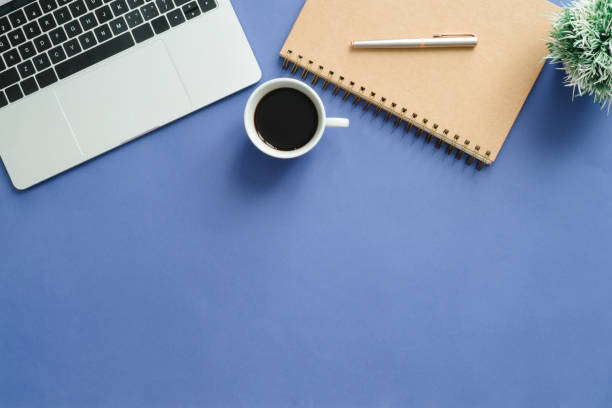istock Minimal work space - Creative flat lay photo of workspace desk. Top view office desk with laptop, notebooks and coffee cup on blue color background. Top view with copy space, flat lay photography. 931053142