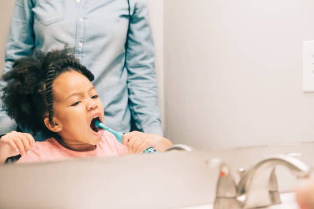 istock little girl brushing her teeth 931053266