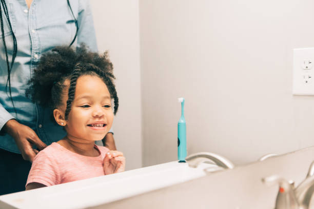 istock little girl smiling in mirror after brushing her teeth 931053306