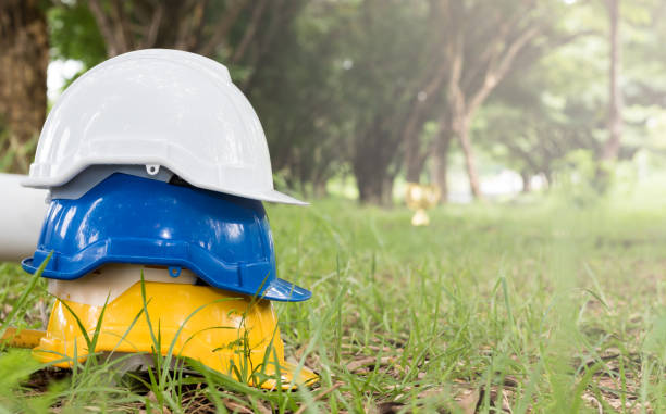 istock stack of yellow blue and white safety helmet yellow blue and white on grass 931053312
