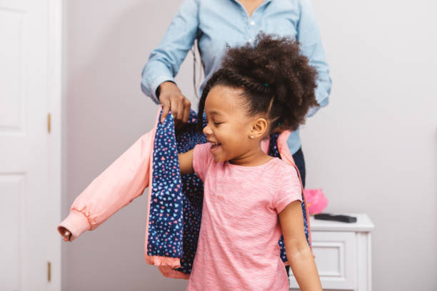 little girl getting ready for school - coat imagens e fotografias de stock