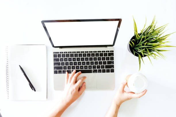 istock Top view of hand use laptop computer with blank screens on white office desk table.Flat lay 931055664