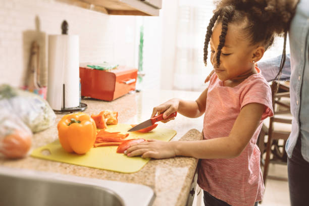 istock mother and daughter cutting vegetables 931055934