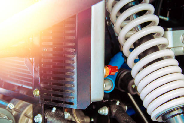 reinforced suspension of a sports snowmobile close-up. white shock absorber spring and engine cooling radiator. sunny warm flare. - motor neuron imagens e fotografias de stock