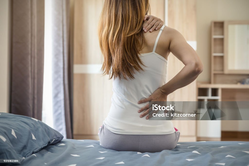 Femme souffrant de mal de dos sur le lit - Photo de Mal de dos libre de droits