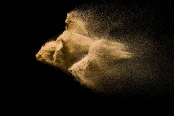 istock Abstract sand cloud. Golden colored sand splash agianst dark background. Yellow sand fly wave in the air. Sand explode on black background ,throwing freeze stop motion. 931082834